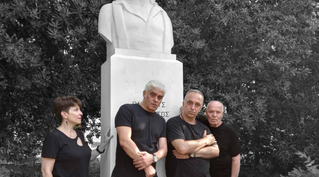 Τέσσερις ηθοποιοί της παράστασης ποζάρουν για το δελτίο τύπου σε ένα άγαλμα εξωτερικού τοπίου.