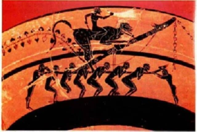 αττικό αγγείο του 560 π.Χ. Αναπαριστά .μια φαλλική πομπή, όπου οι πανηγυριστές κουβαλούν στους ώμους τους έναν υπερμεγέθη φαλλό. Αρχαία κωμωδία. πηγή: phalliphoria.gr