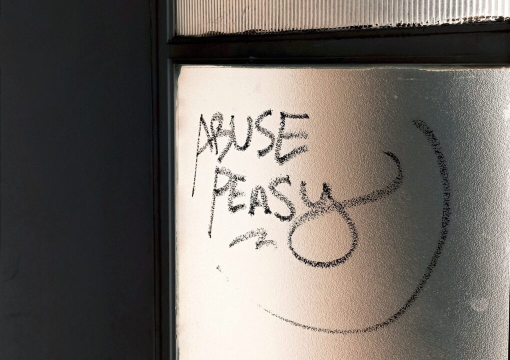 Γραφίτι σε παράθυρο που γράφει "abuse peasy", που σημαίνει εύκολη κακοποίηση