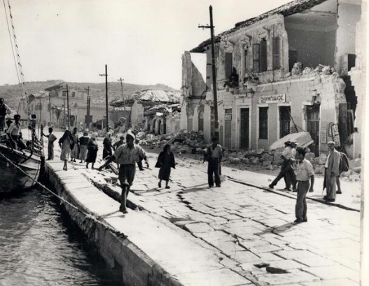 Οι κάτοικοι του Αργοστολίου μετά τον φονικό σεισμό του 1953, περιμένοντας τα μικρά πλοία που θα τους μεταφέρουν στην ηπειρωτική Ελλάδα | Πηγή Εικόνας: Keystone Press